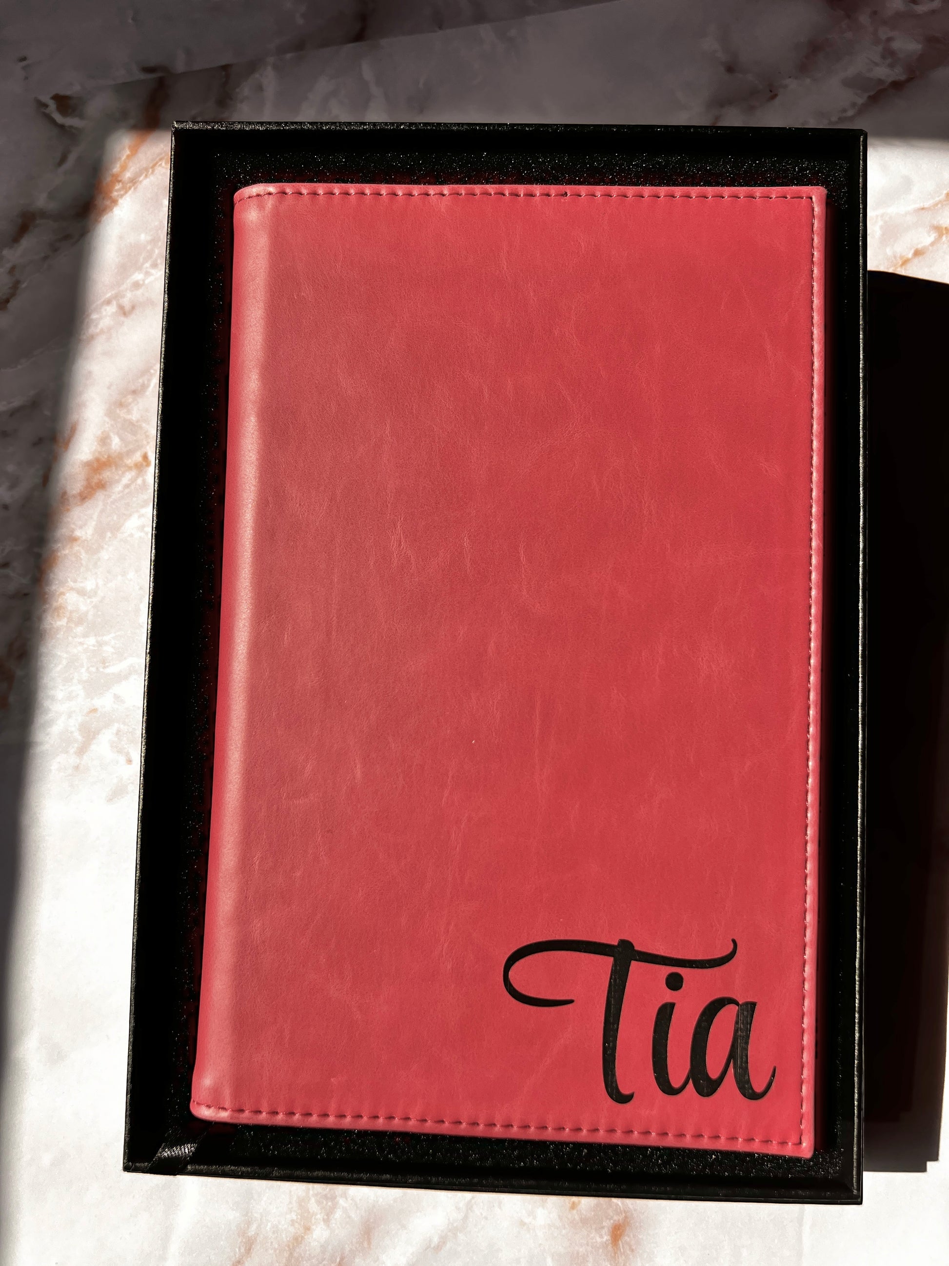 Pink leather-bound book with name embossed on it