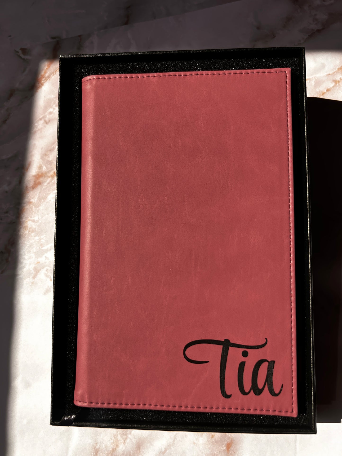 Pink leather-bound book with name embossed on it